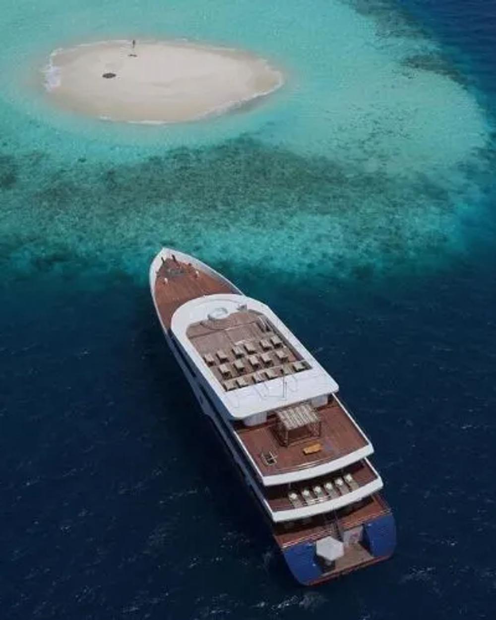 A charter yacht cruising Maldivian waters beyond the shoreline