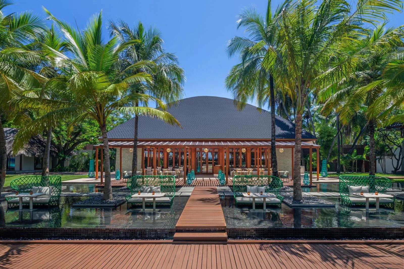 KITCHEN, W Maldives' all-day dining pavilion, its domed roof set among palm trees at the end of a reflecting-pool walkway