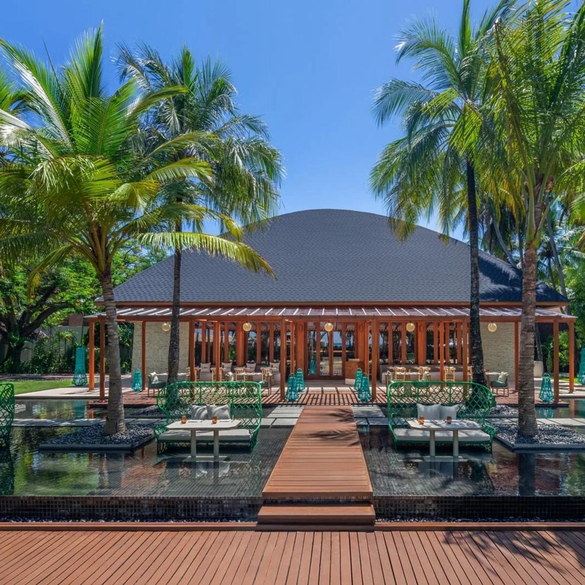 KITCHEN, W Maldives' all-day dining pavilion, its domed roof set among palm trees at the end of a reflecting-pool walkway