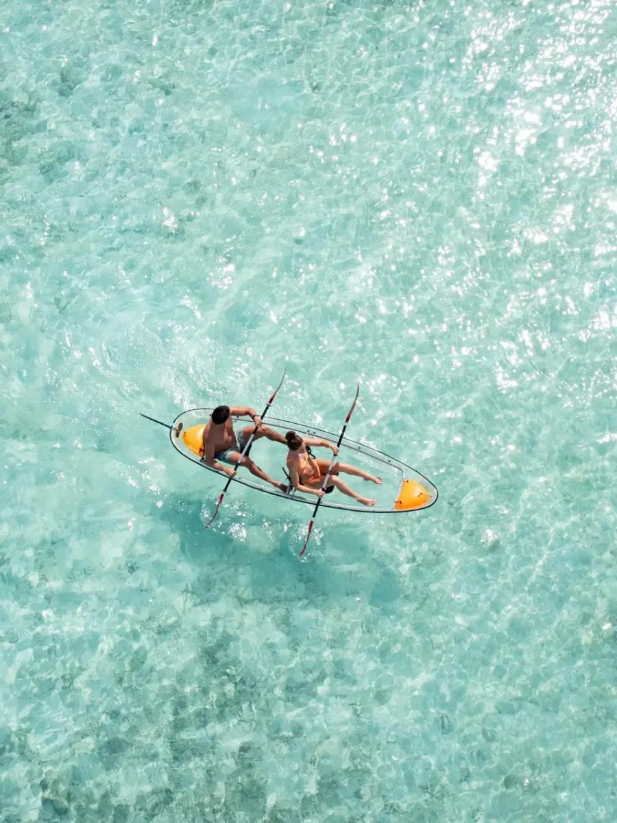 A stand-up paddleboarder crossing the lagoon at Niva Kurumba, seen from above