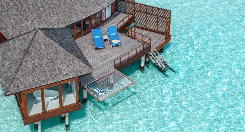 Aerial view of an over-water suite deck and the surrounding reef at Anantara Dhigu