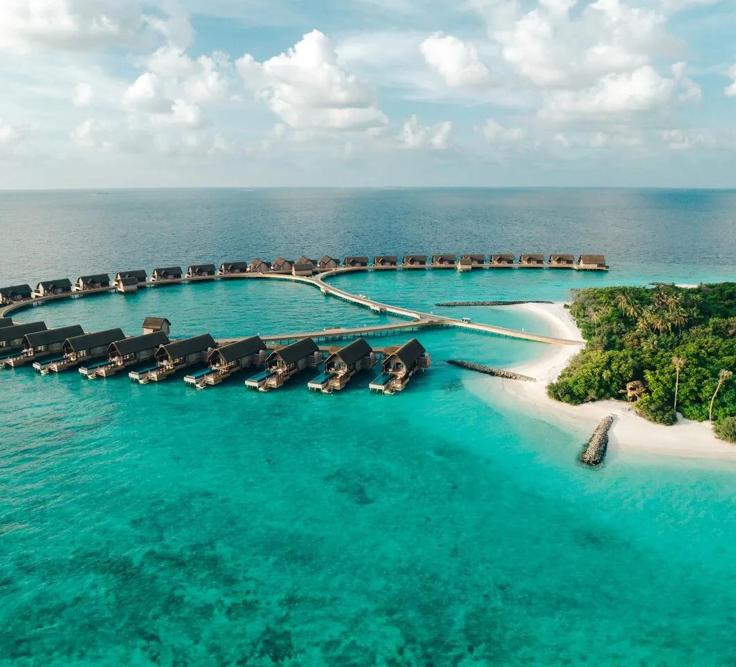 Aerial view of Bodufushi Island, Joali Being's overwater and beach villas ringed by Raa Atoll's lagoon