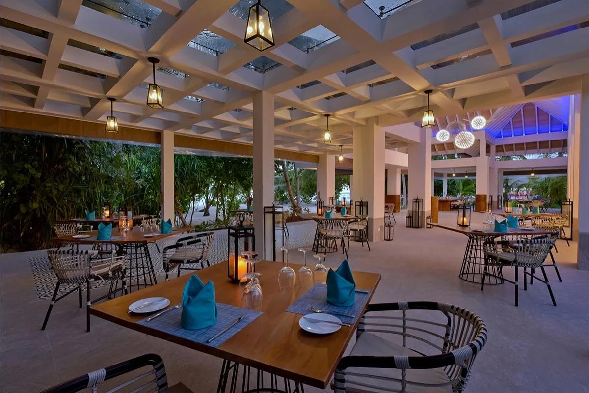 Azure's garden dining area, lanterns lit over set tables in the evening
