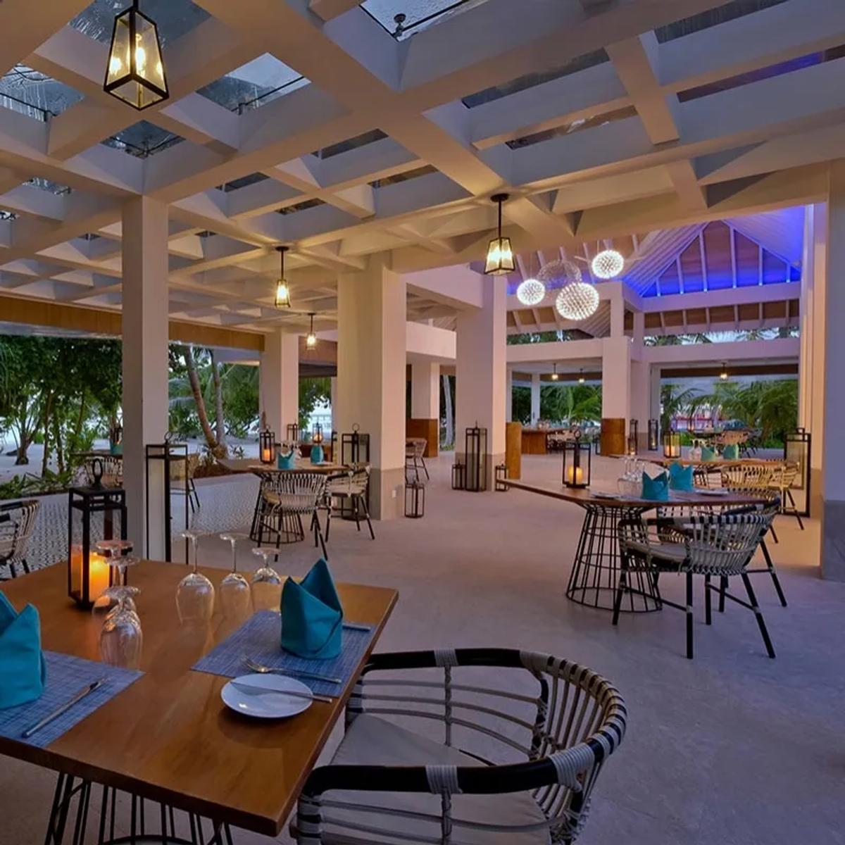 Azure's garden dining area, lanterns lit over set tables in the evening