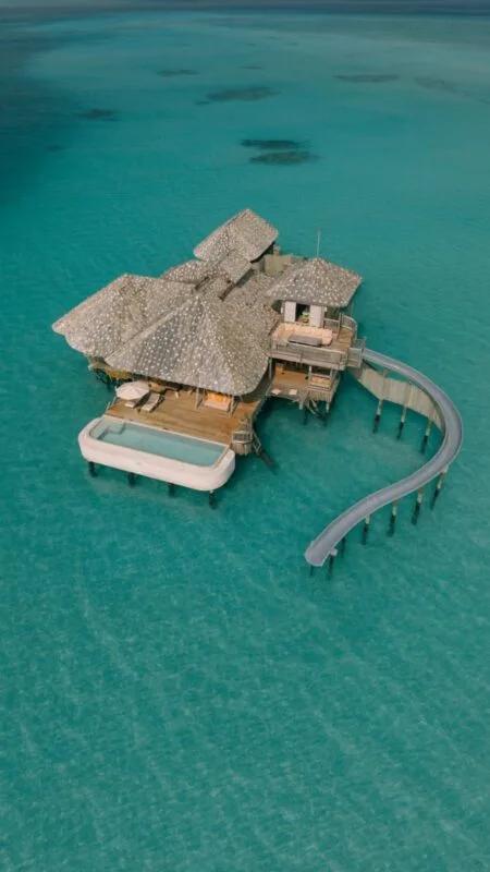 Aerial view of a One-Bedroom Overwater Sea Loft villa reaching into the lagoon at Soneva Secret