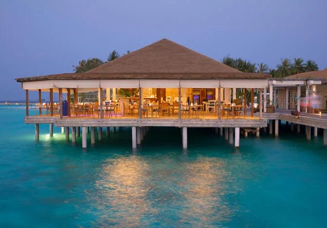 Mare Azzurro's overwater dining room lit from within as evening falls