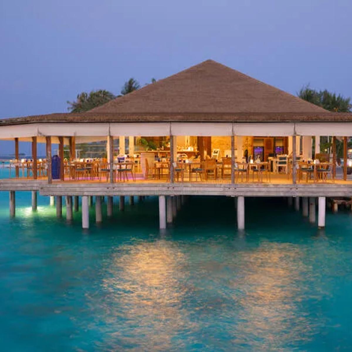 Mare Azzurro's overwater dining room lit from within as evening falls