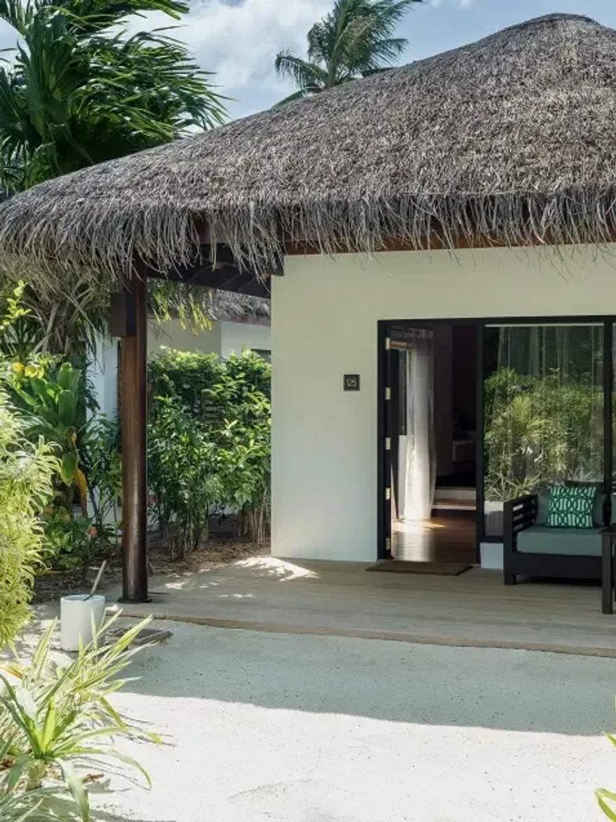 Deluxe Villa with Pool's garden entrance, thatched roof over a shaded outdoor lounge