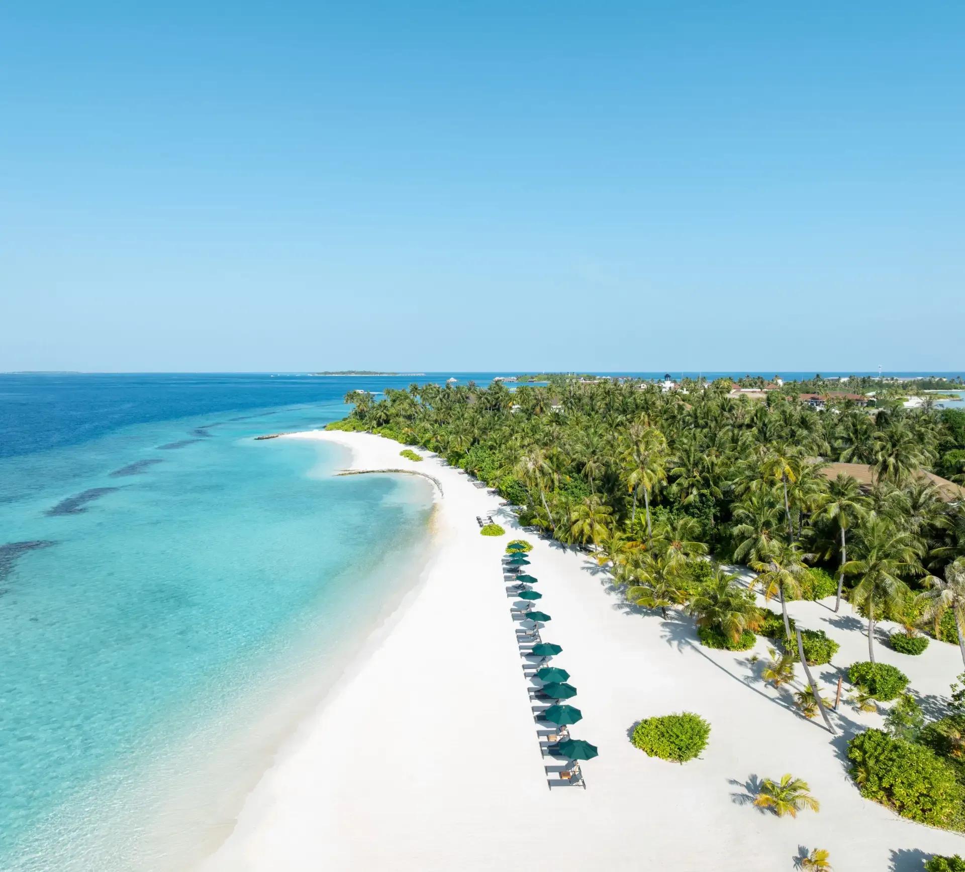 Aerial view of SAii Lagoon Maldives, showing the overwater villa row linked by boardwalk to the neighbouring beach island
