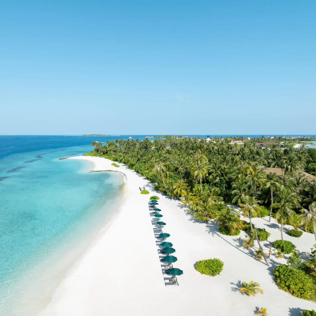 Aerial view of SAii Lagoon Maldives, showing the overwater villa row linked by boardwalk to the neighbouring beach island