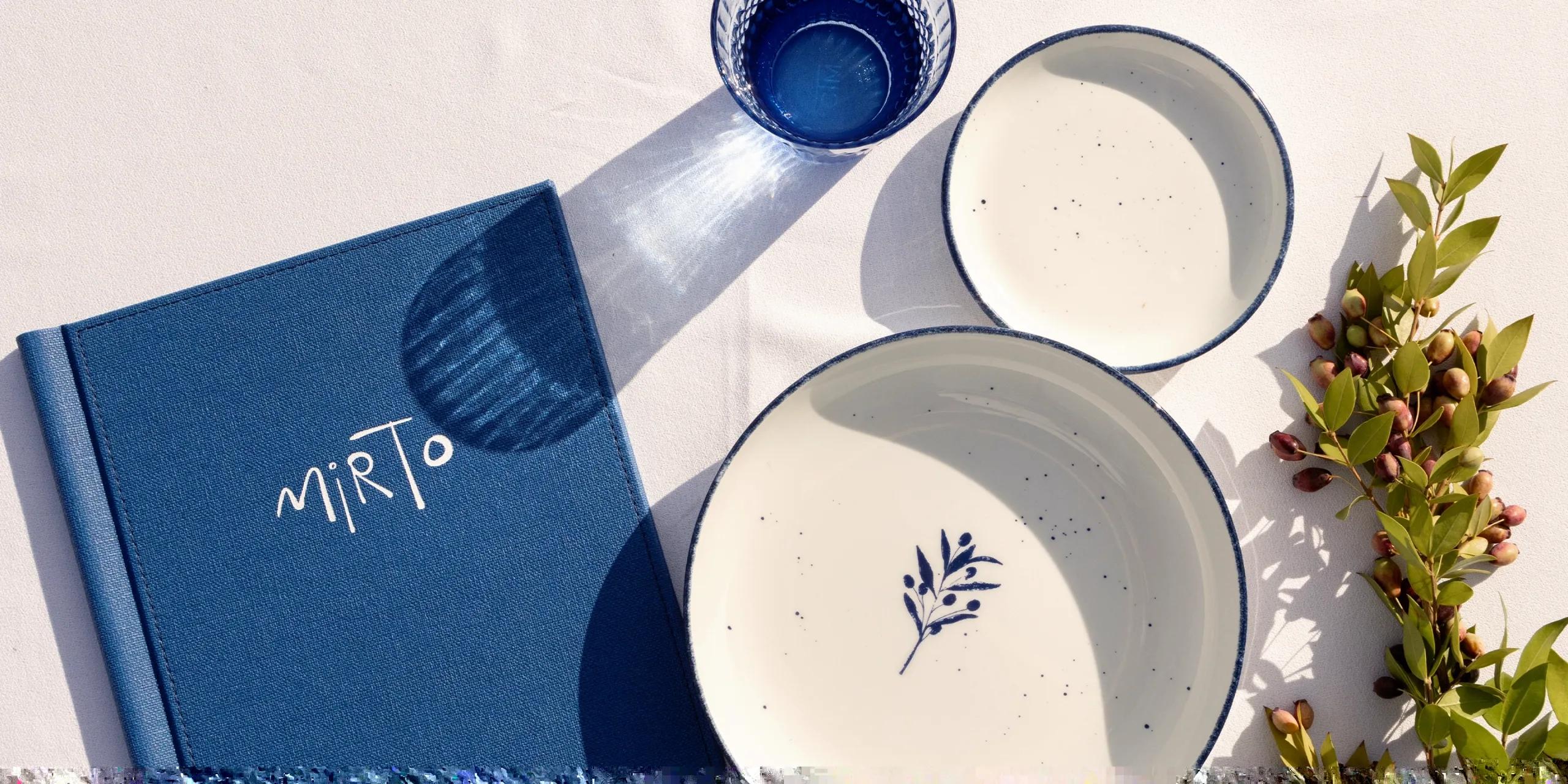A flat-lay of Mirto Pool Bar's menu and hand-painted ceramic tableware, Baglioni Maldives
