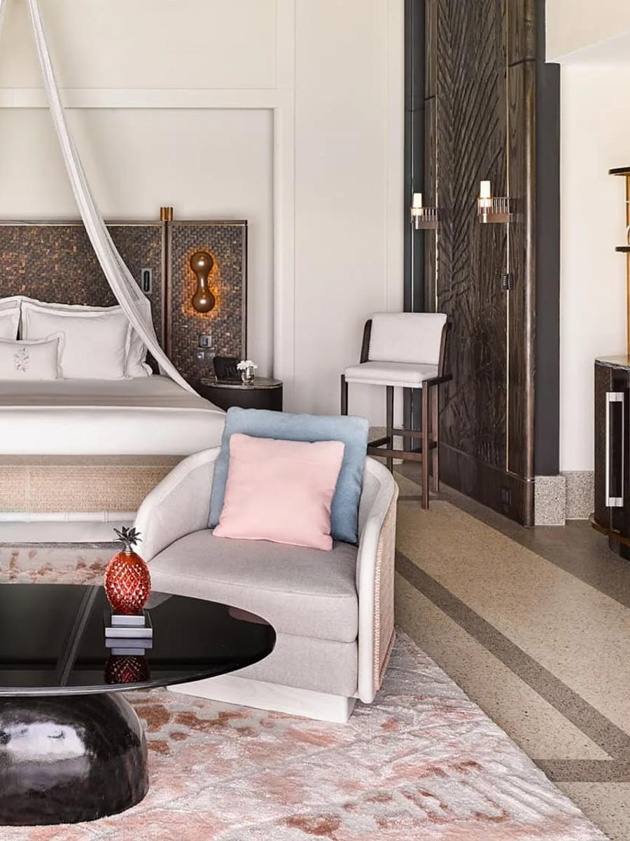 The king bedroom of a Water Villa with Pool, with a sheer canopy over the bed and a dark woven headboard