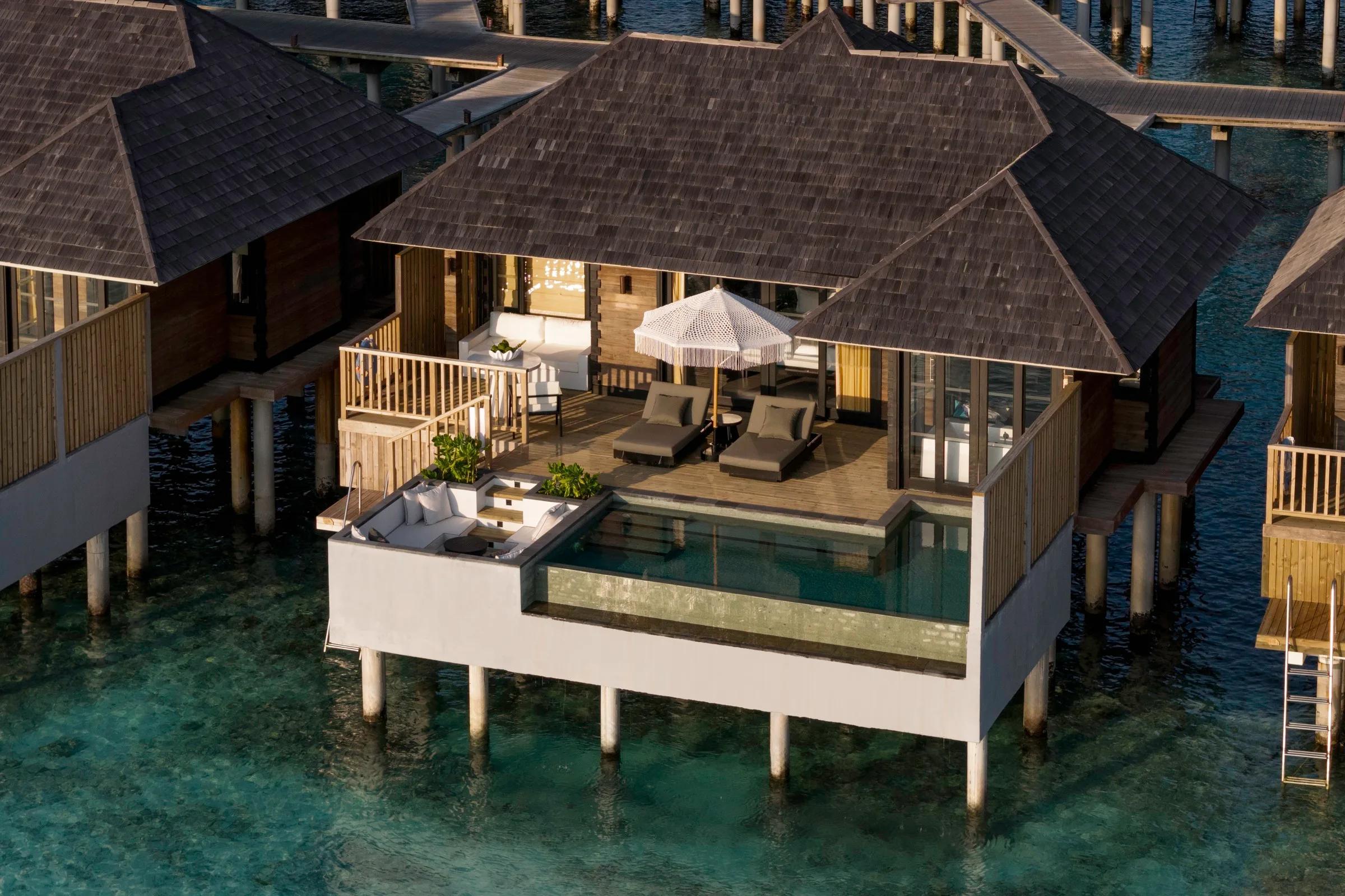 Aerial view of a Horizon Water Villa with Pool, its deck, private pool and lounge seating built out over clear lagoon water