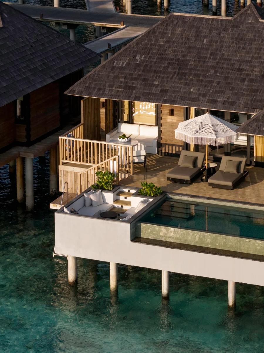 Aerial view of a Horizon Water Villa with Pool, its deck, private pool and lounge seating built out over clear lagoon water