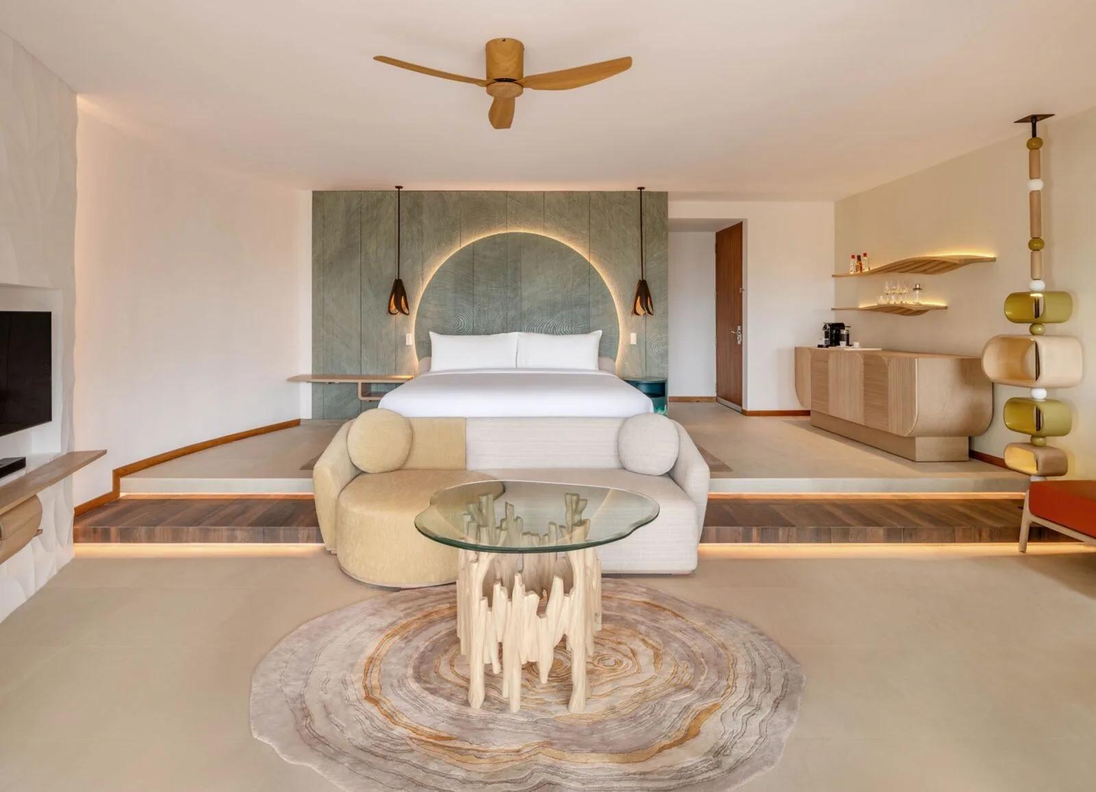 A villa bedroom at W Maldives with a round backlit headboard under a thatched roof — representative of the Escape Remix category; a dedicated photograph was not available
