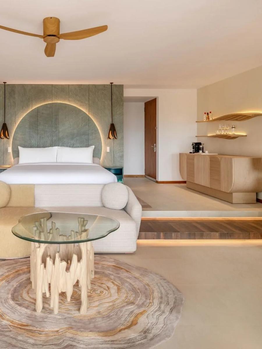 A villa bedroom at W Maldives with a round backlit headboard under a thatched roof — representative of the Escape Remix category; a dedicated photograph was not available