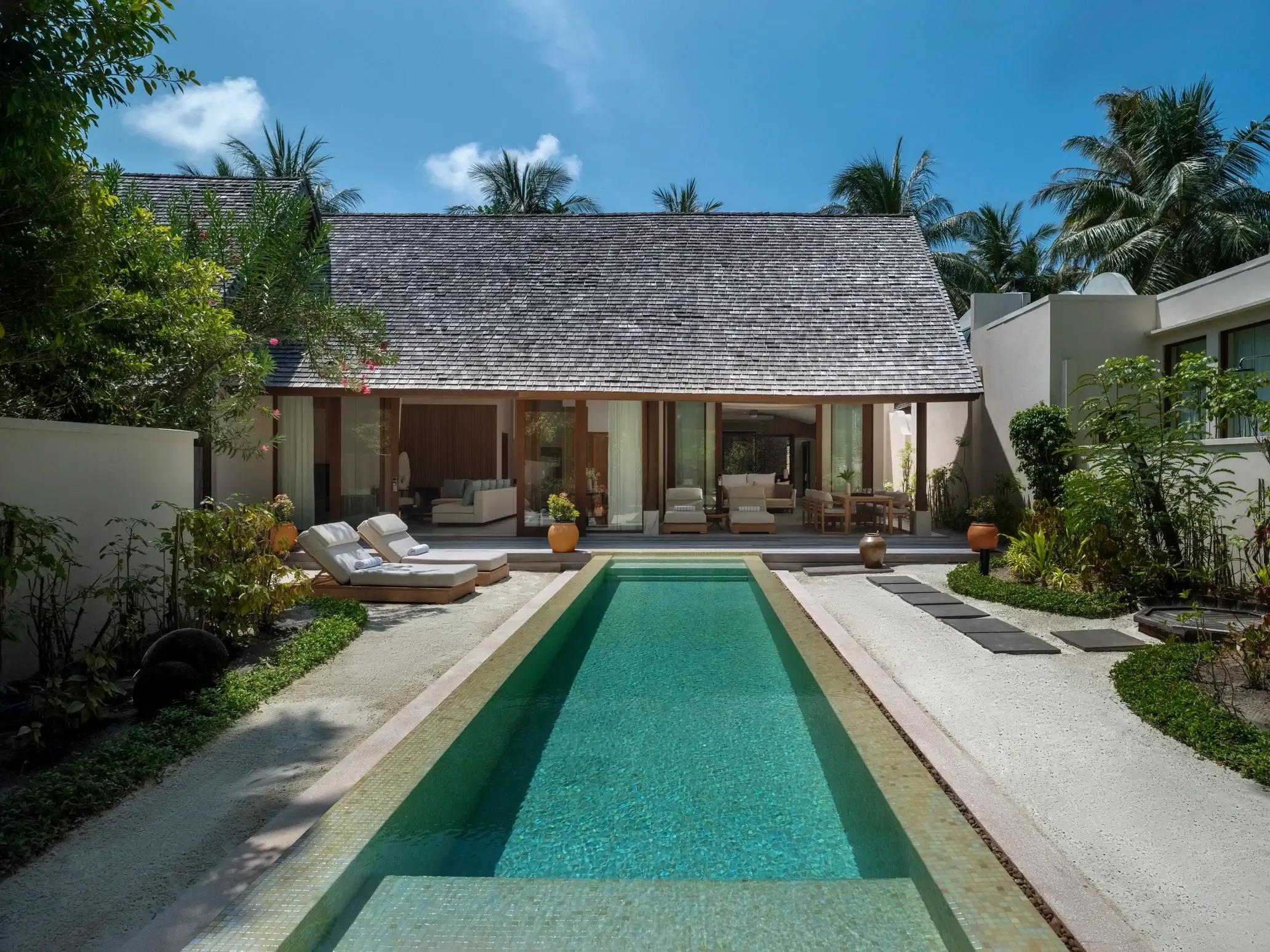 The shingle-roofed Three-Bedroom Beach Suite and its lap pool at Conrad Maldives Rangali