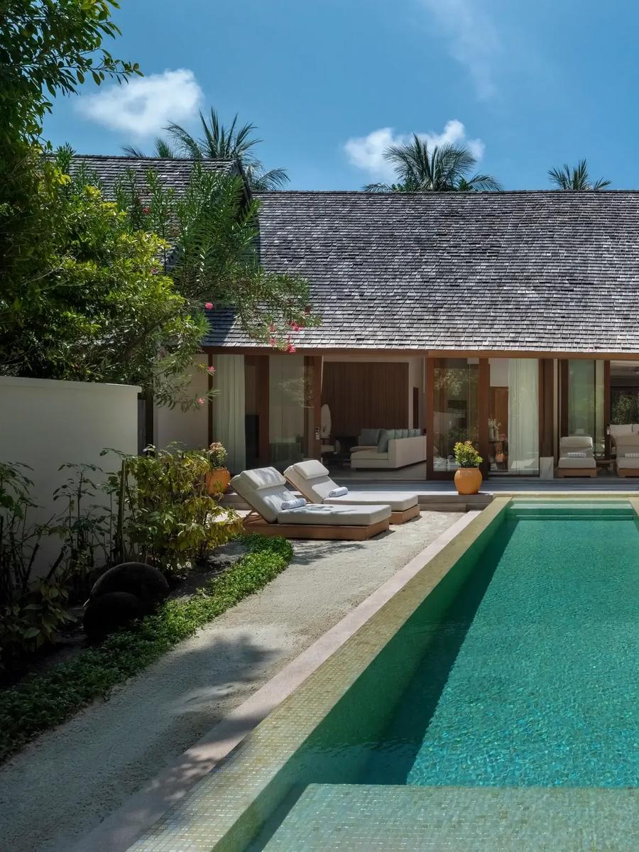 The shingle-roofed Three-Bedroom Beach Suite and its lap pool at Conrad Maldives Rangali