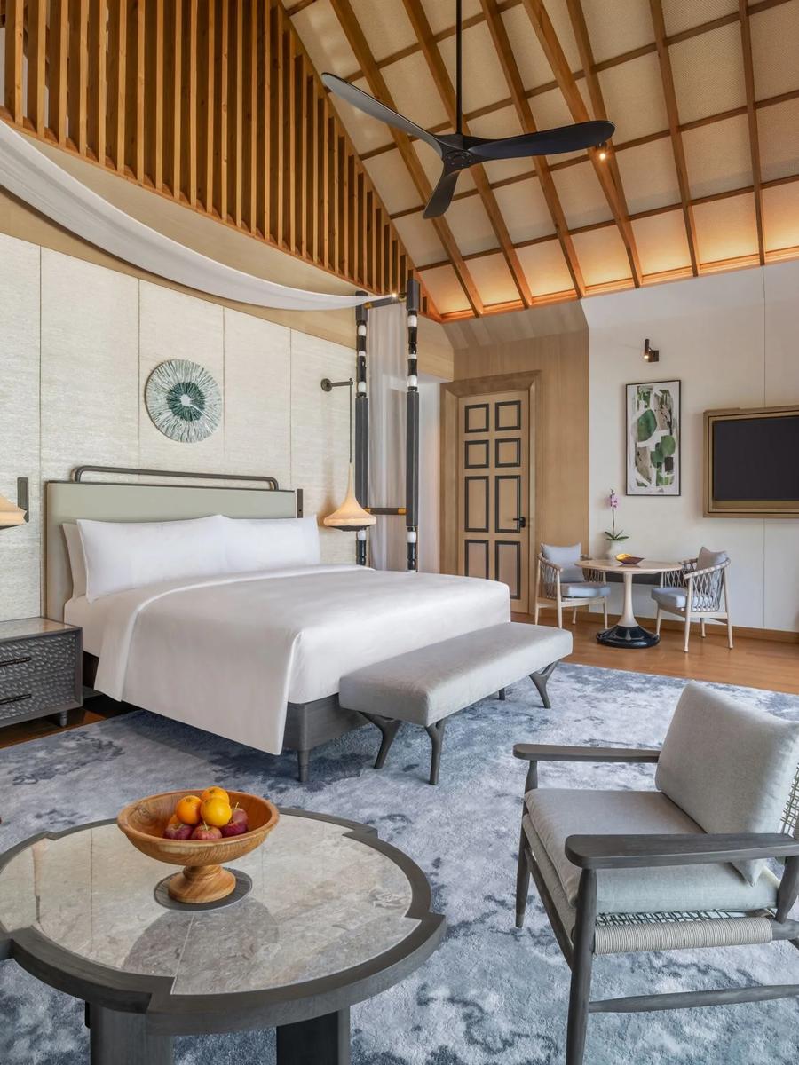 A Beach Pool Villa's bedroom, opening onto its deck and pool