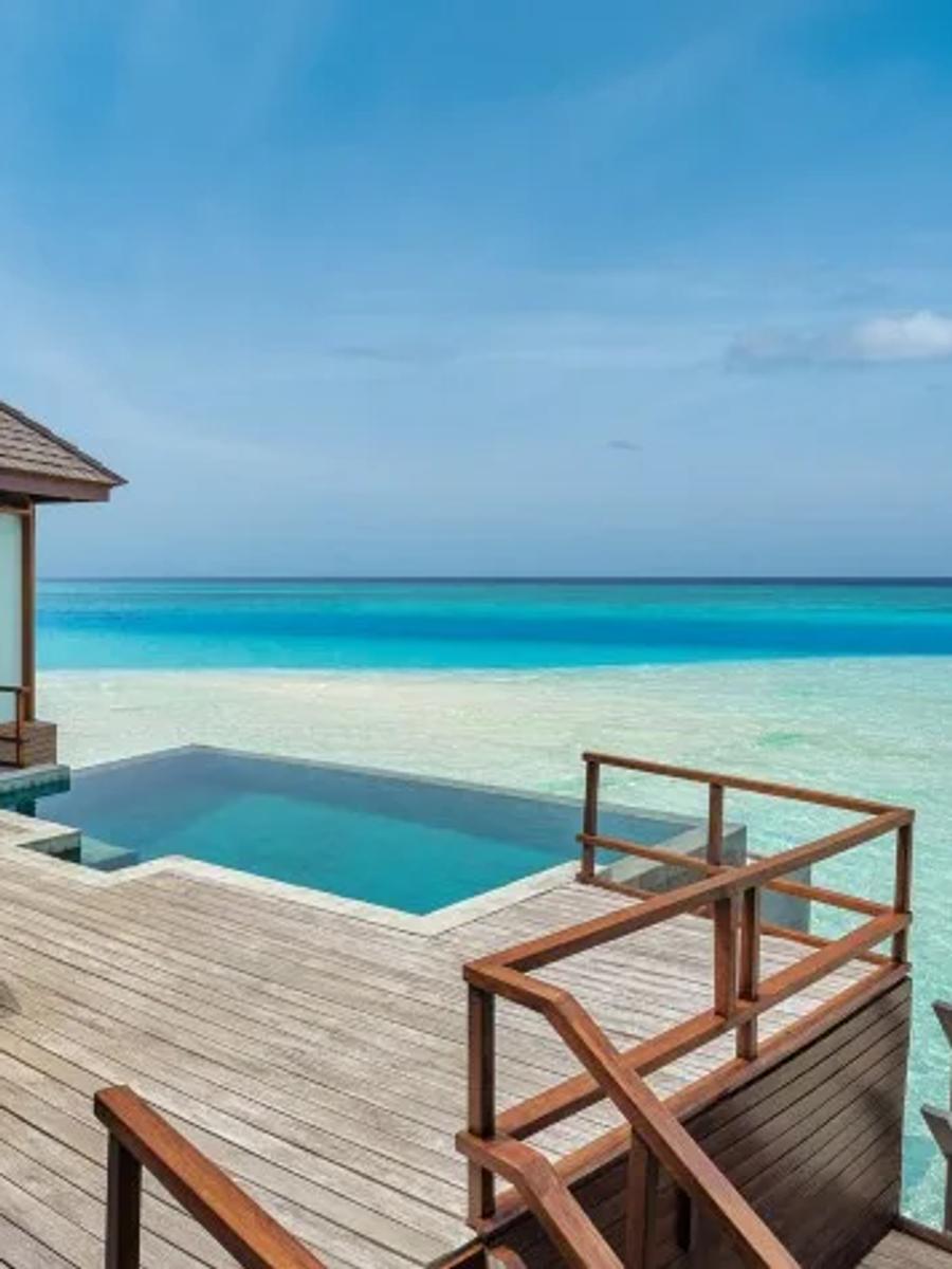 The infinity pool and deck of a Sunset Over Water Pool Suite, perched above the sea