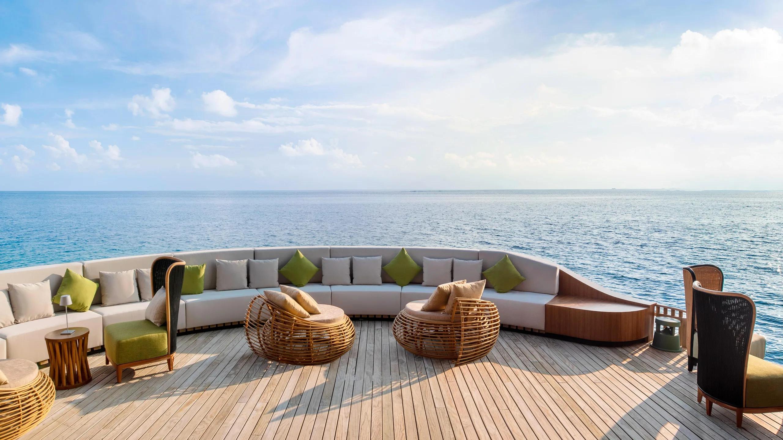 The Pearl's curved overwater lounge deck, seating arranged to face the open ocean
