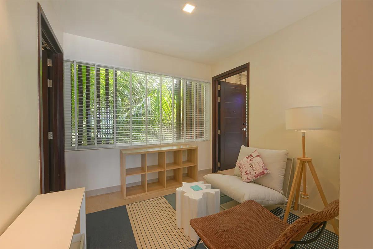 A sitting nook inside a Two-Bedroom Family Sky Suite, opening onto a private balcony