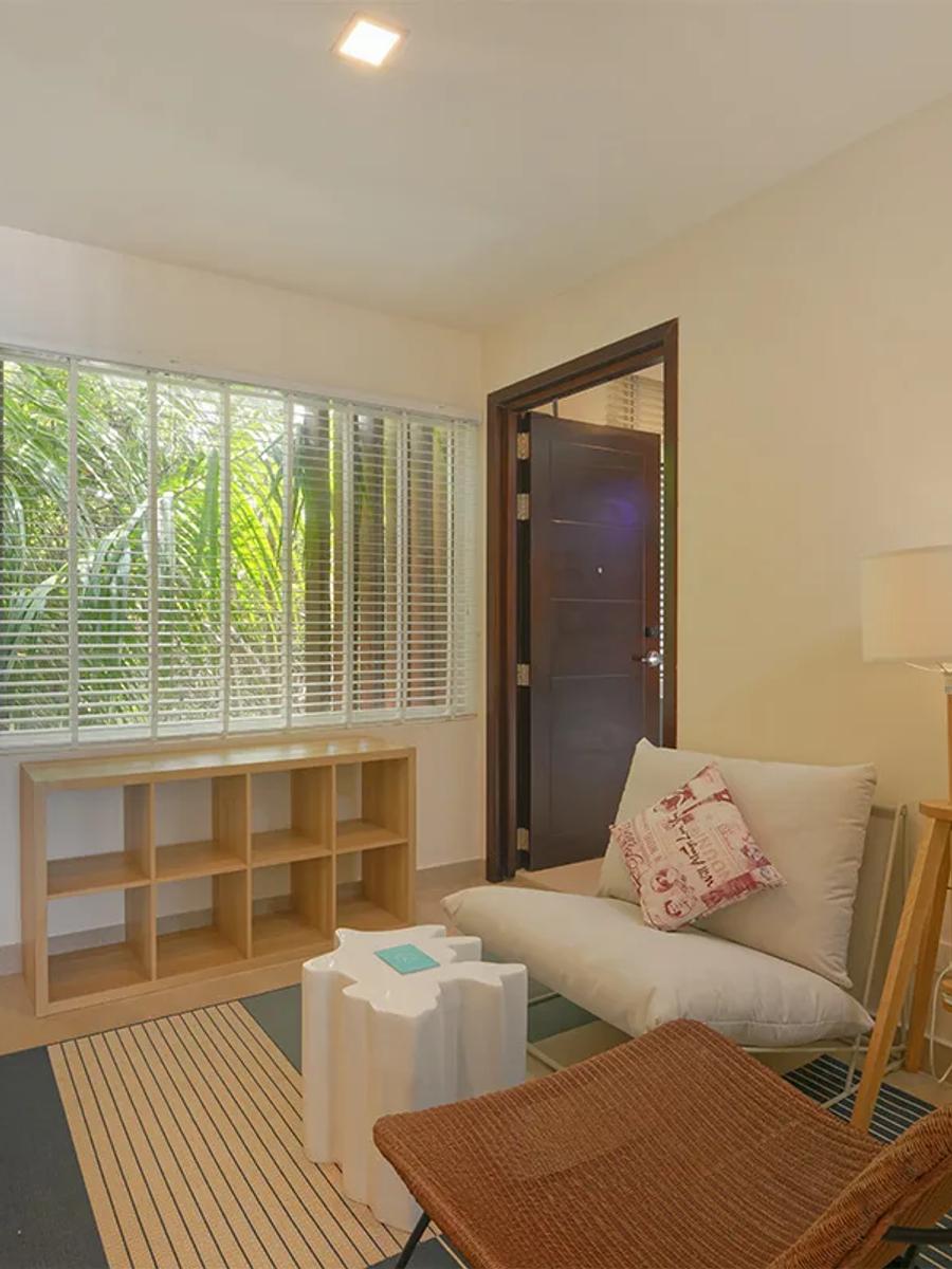 A sitting nook inside a Two-Bedroom Family Sky Suite, opening onto a private balcony