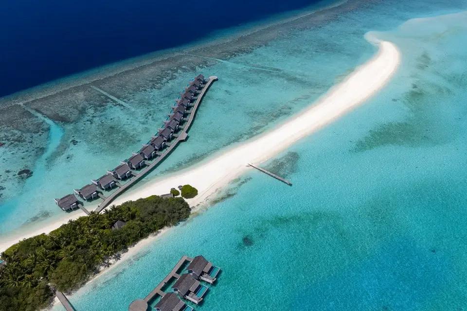 Aerial view of the sandbank off Thundi Point stretching out into the lagoon, overwater villas along its near edge