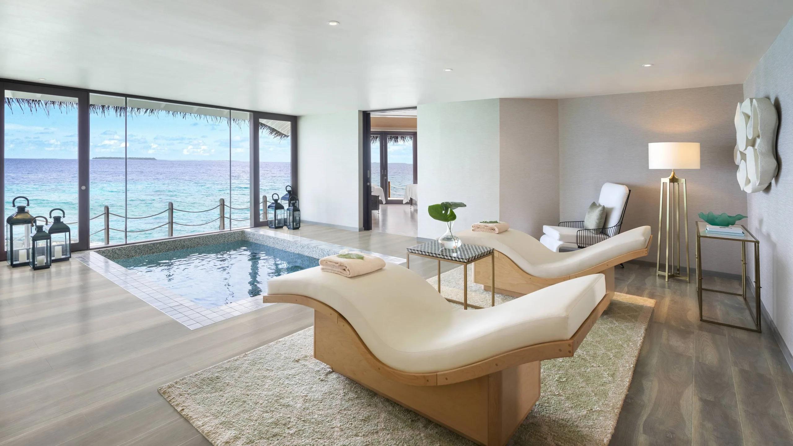 A couples' treatment room at Spa by JW, two beds set side by side facing the sea