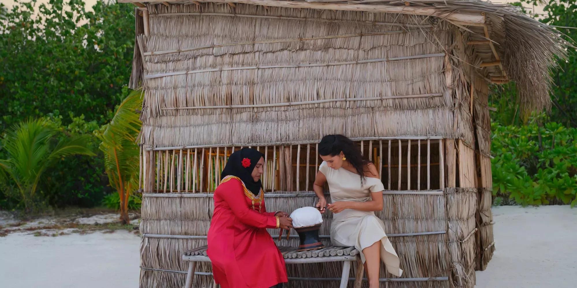 A guest learns a traditional craft at The Maldivian House, Noku Maldives' small exhibit of island heritage