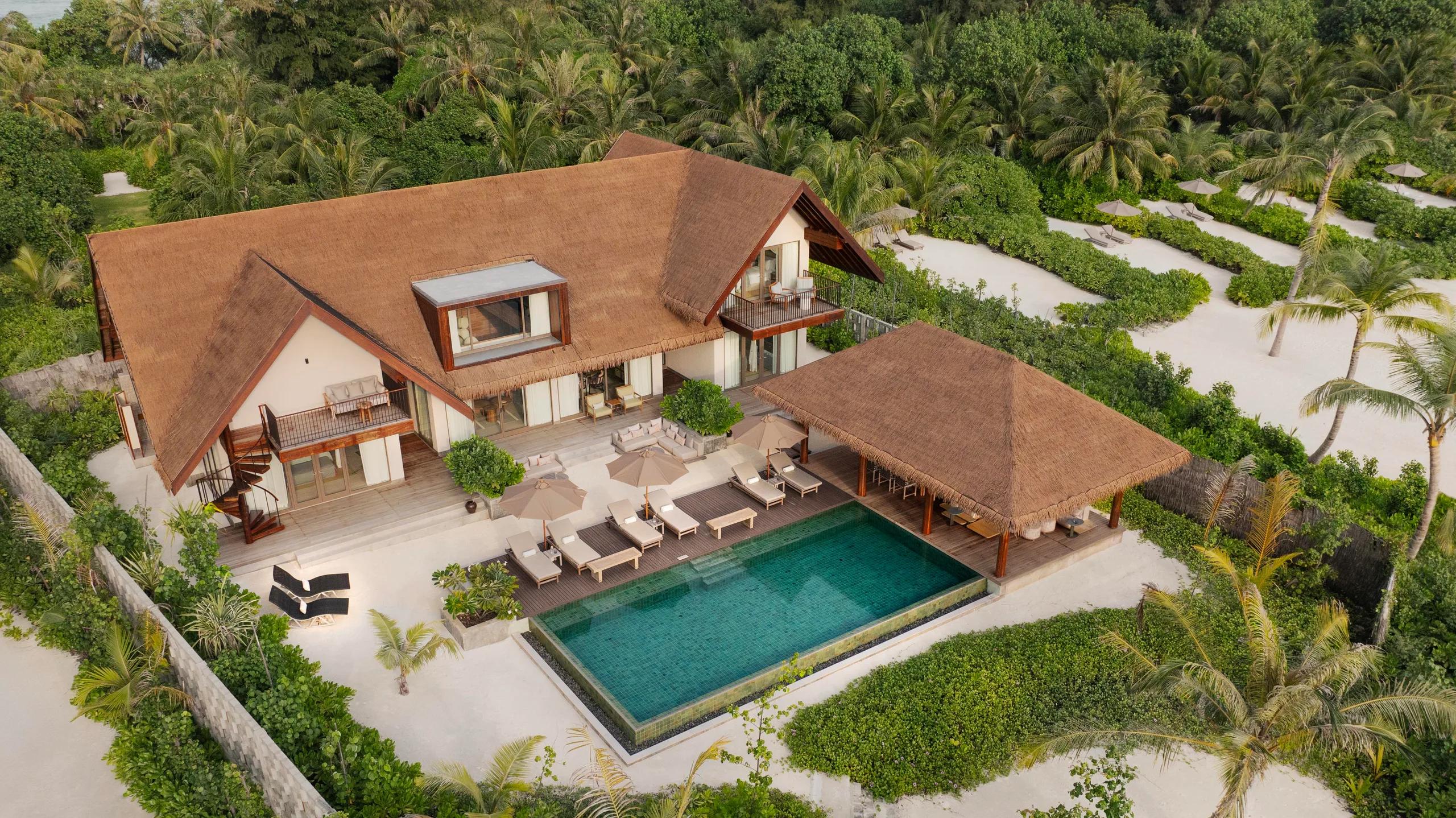 Aerial view of the Three Bedroom Beach Reserve, its extended thatched roofline, pool pavilion, and private beach frontage.