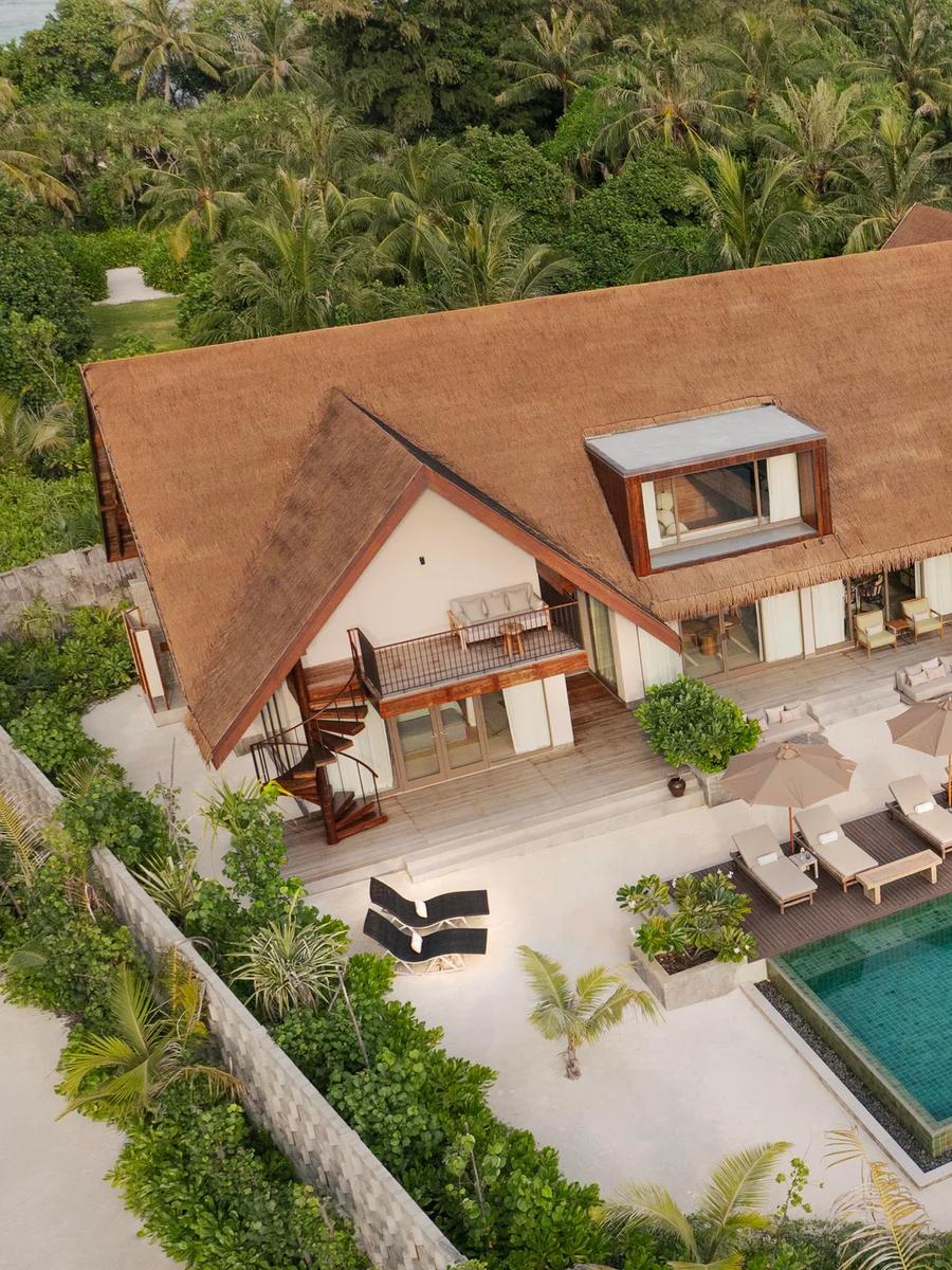 Aerial view of the Three Bedroom Beach Reserve, its extended thatched roofline, pool pavilion, and private beach frontage.