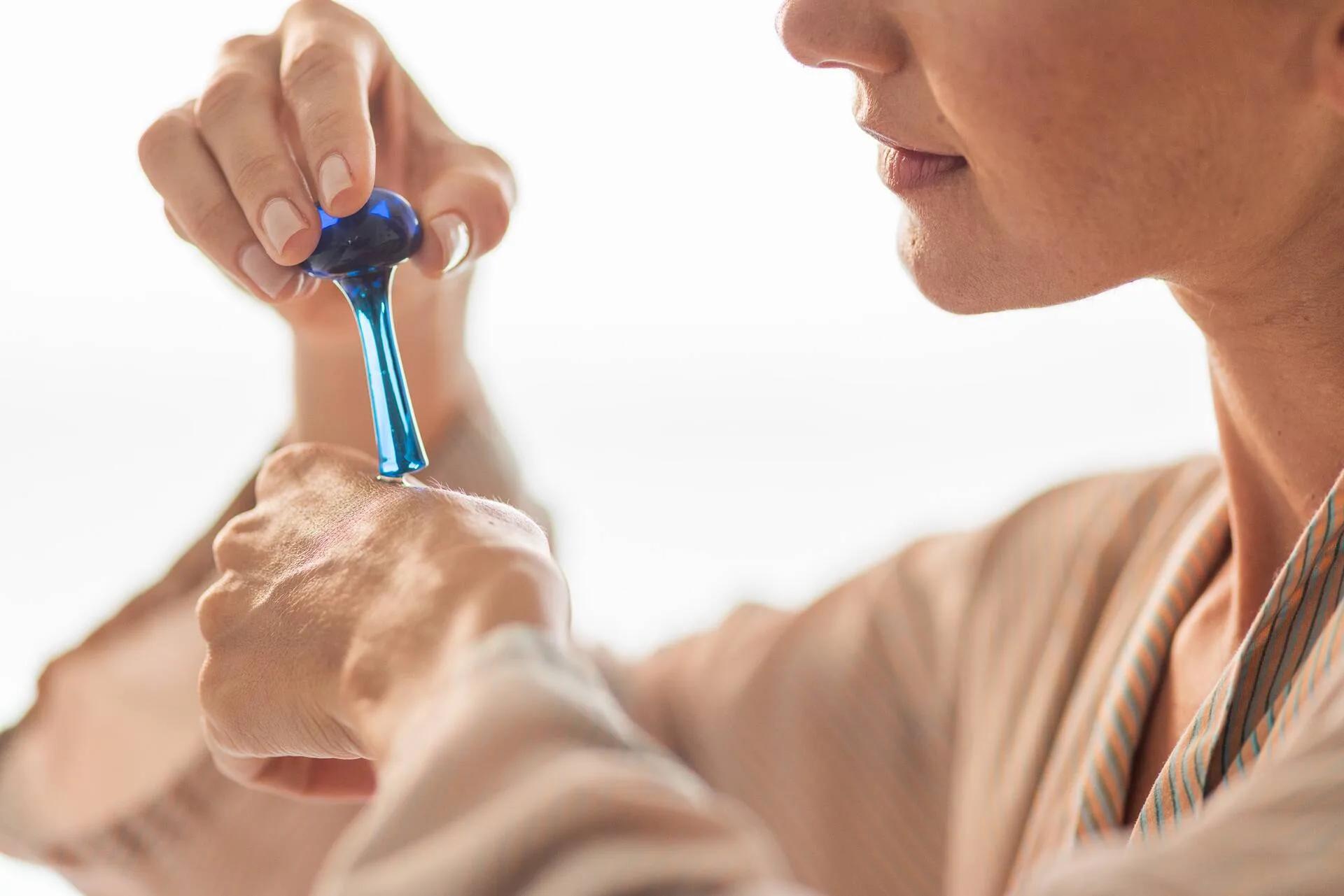 Close-up of a blue crystal wand being used on a guest's shoulder during a skincare ritual at The Standard Spa