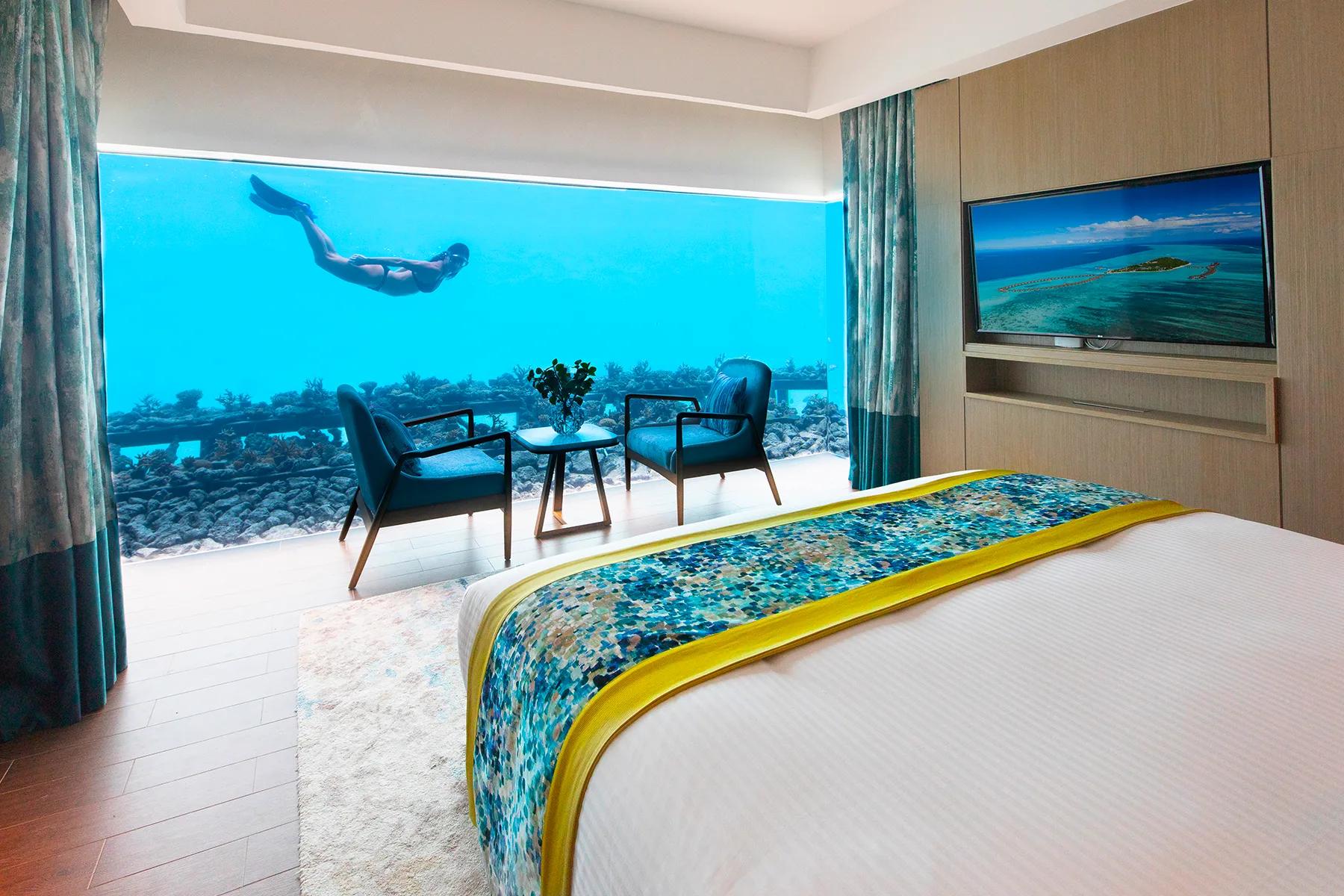 The submerged underwater bedroom inside an Aqua Villa, seen from below the lagoon surface