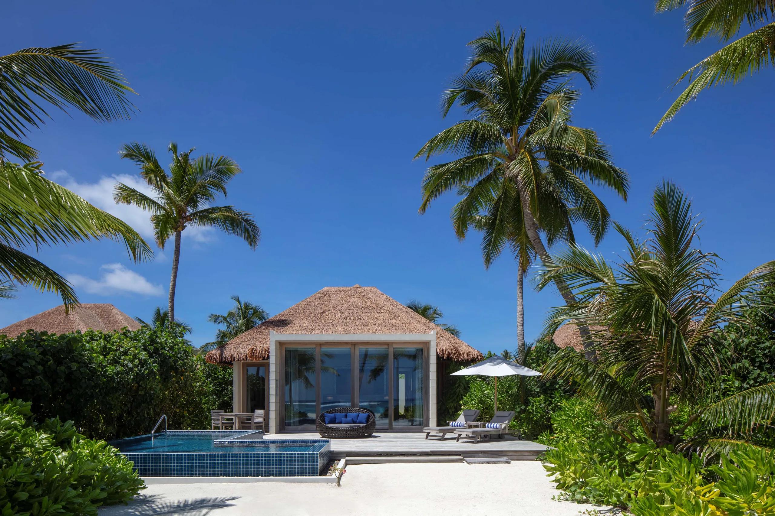 A Beach Villa's private pool and sun deck at Radisson Blu Resort Maldives, set among palm trees on the beach