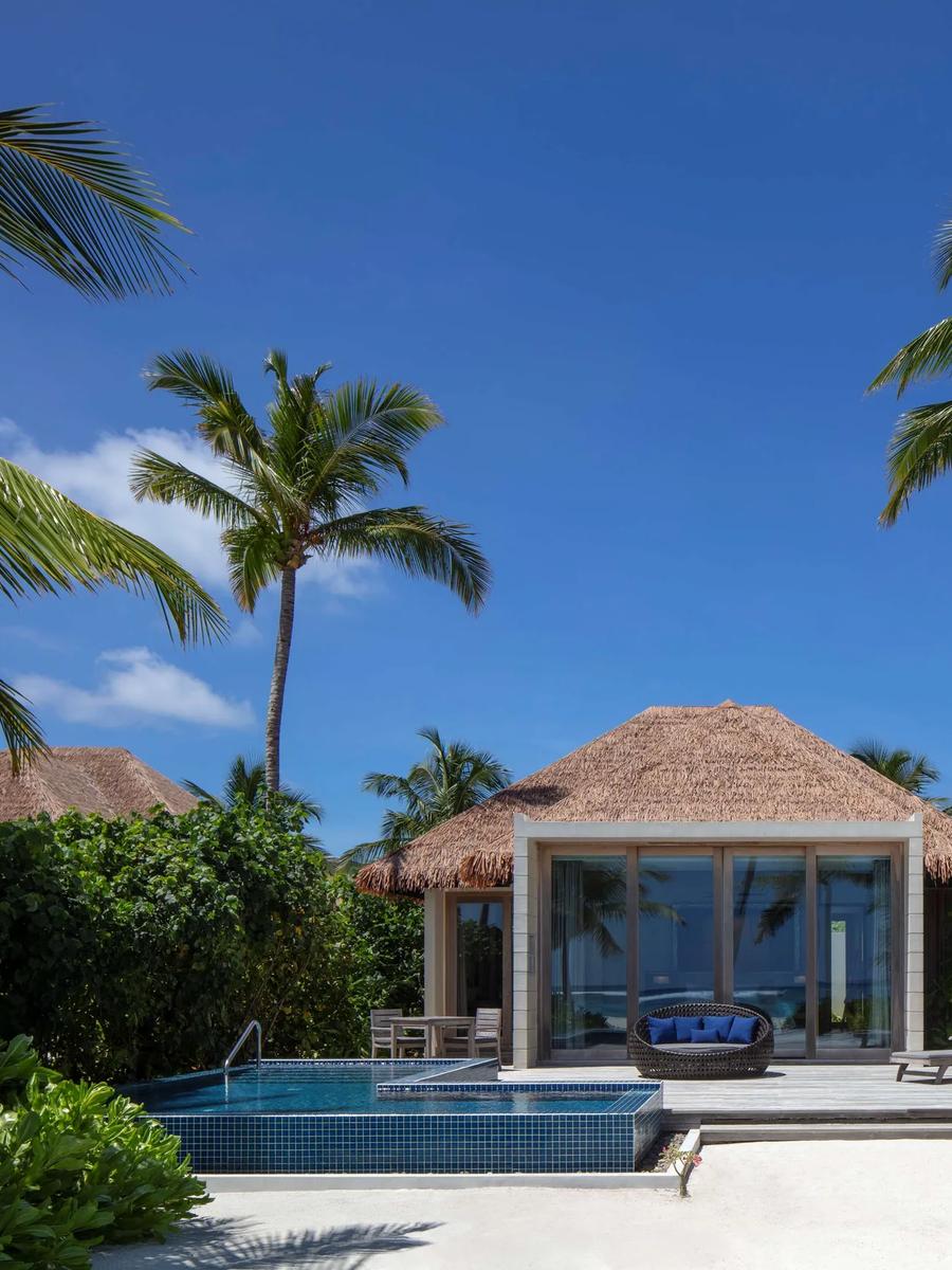 A Beach Villa's private pool and sun deck at Radisson Blu Resort Maldives, set among palm trees on the beach