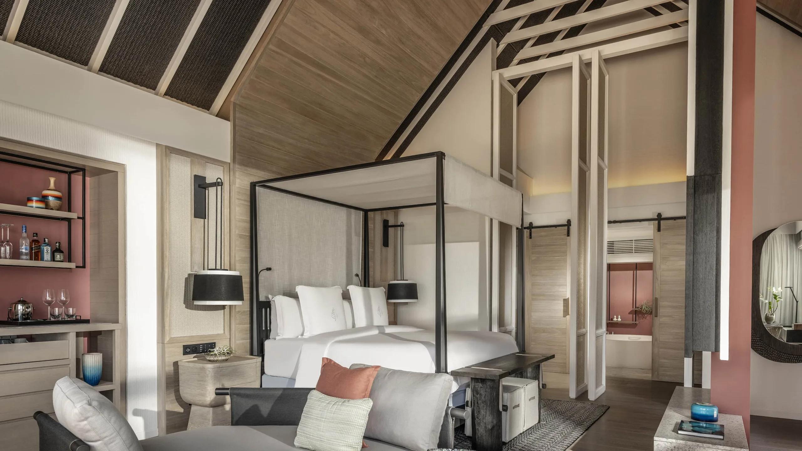 The four-poster bed and private bar nook inside a Two-Bedroom Oceanfront Bungalow with Partial Sea View