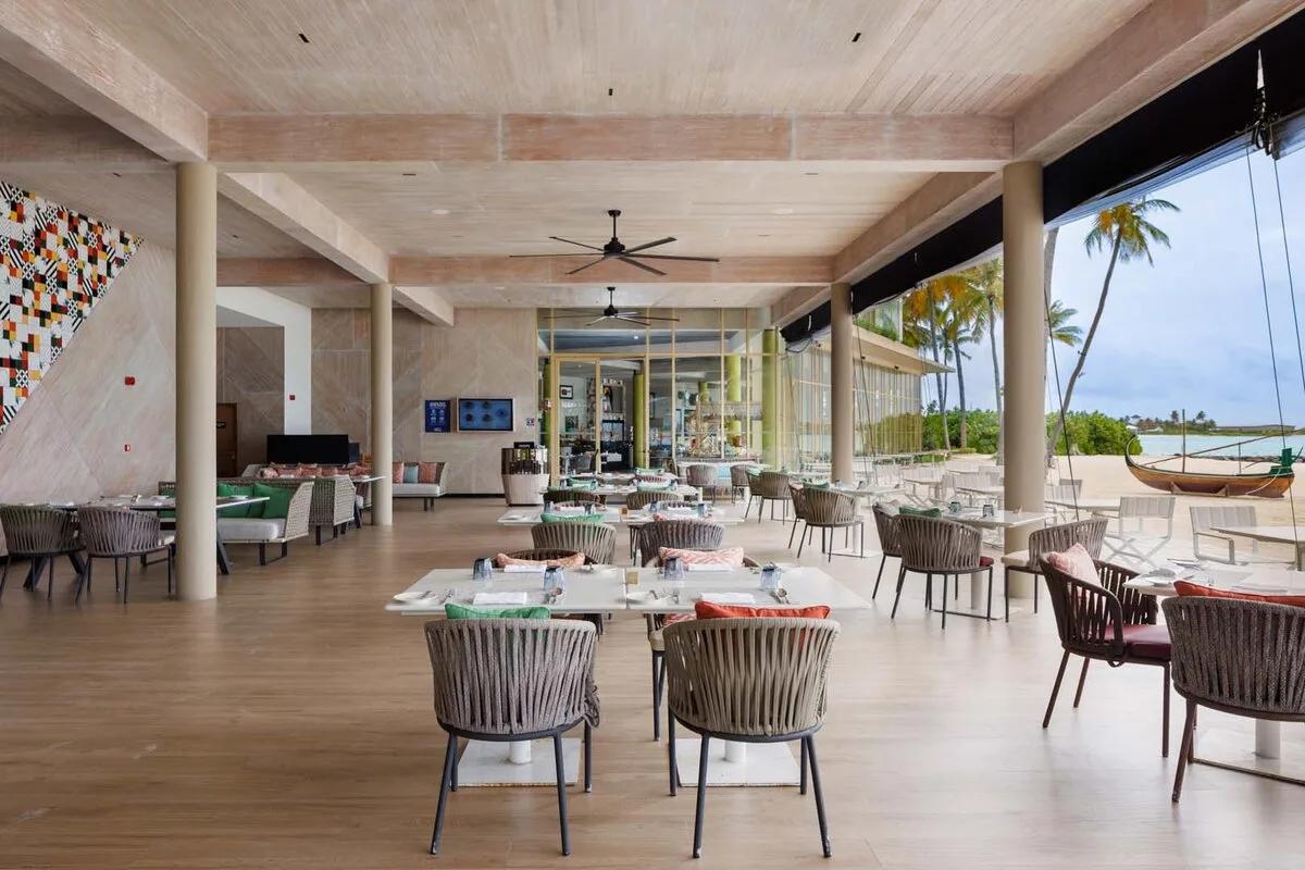 Sessions' dining room, its open kitchen visible through the glass at the back, tables looking out to the beach