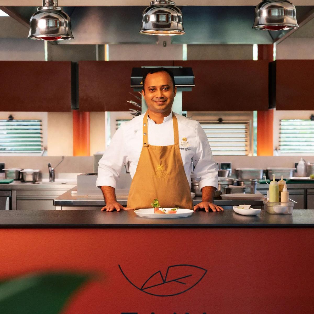 A chef stands behind the open kitchen counter at Faiy, a single plated dish set in front of him