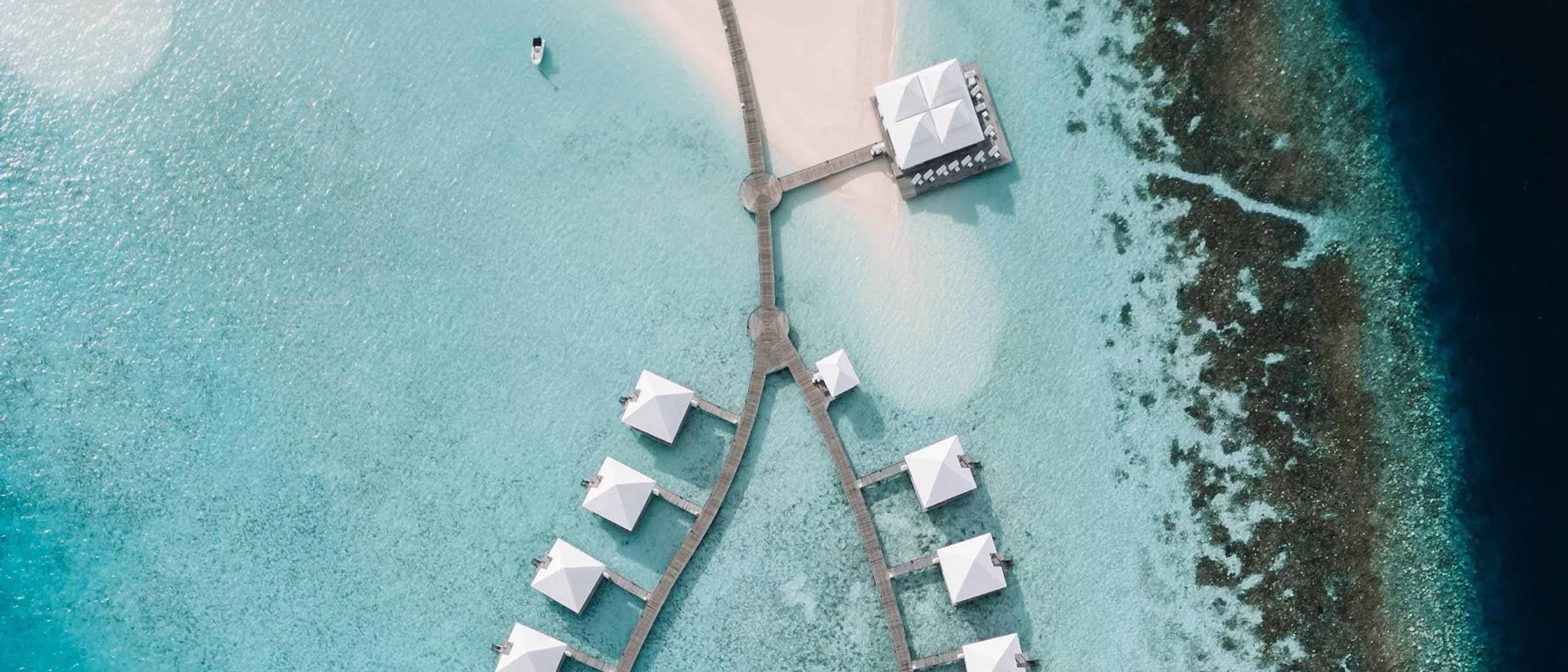 Aerial view of Diamonds Athuruga's water villa jetties, arranged in a Y over the lagoon