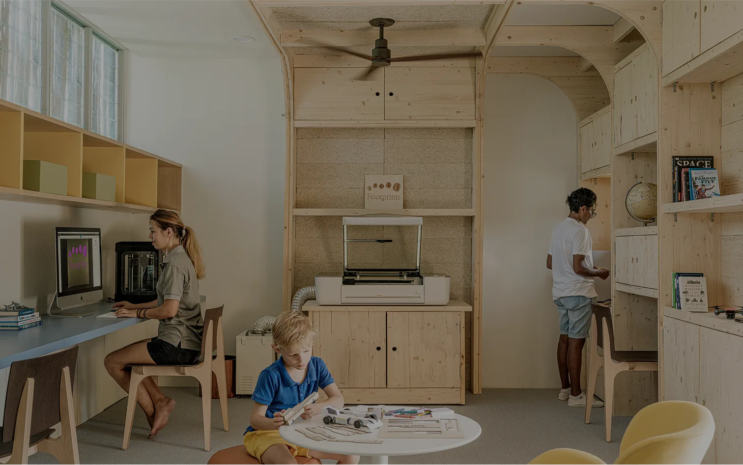 Children and staff working at Footprints' Fab Lab, a 3D printer and laser cutter set into a timber-lined workshop