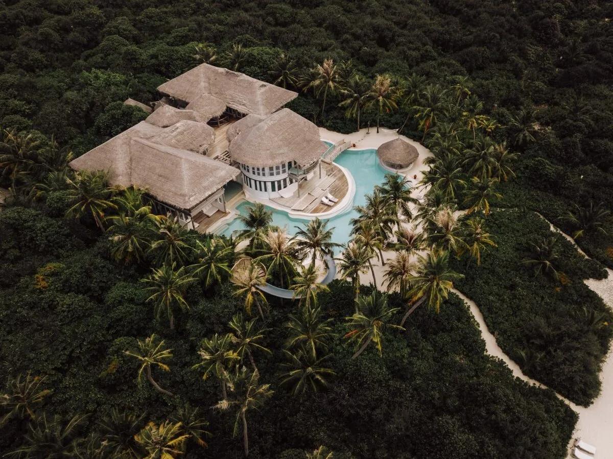 An overwater Water Reserve villa at Soneva Jani, its deck and steps leading down into the lagoon