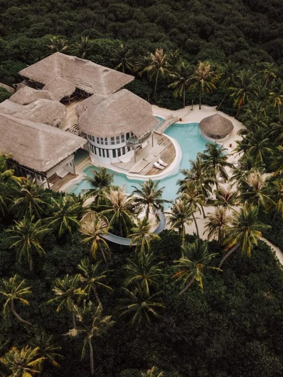 An overwater Water Reserve villa at Soneva Jani, its deck and steps leading into the lagoon; a dedicated photograph of the one-bedroom Water Reserve wasn't in the research pool, so this shot of the same Water Reserve architecture at four-bedroom scale (Villa 28) stands in