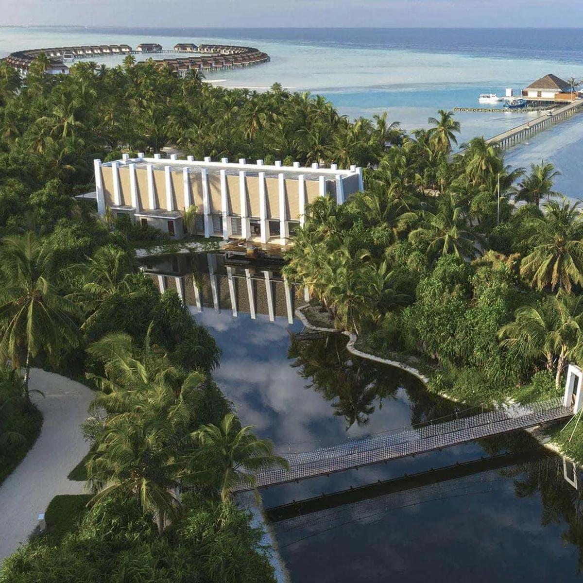 Aerial view of Pullman Maldives Maamutaa's private island, its overwater villas and the natural lake bridge crossing the lagoon in Gaafu Alifu Atoll