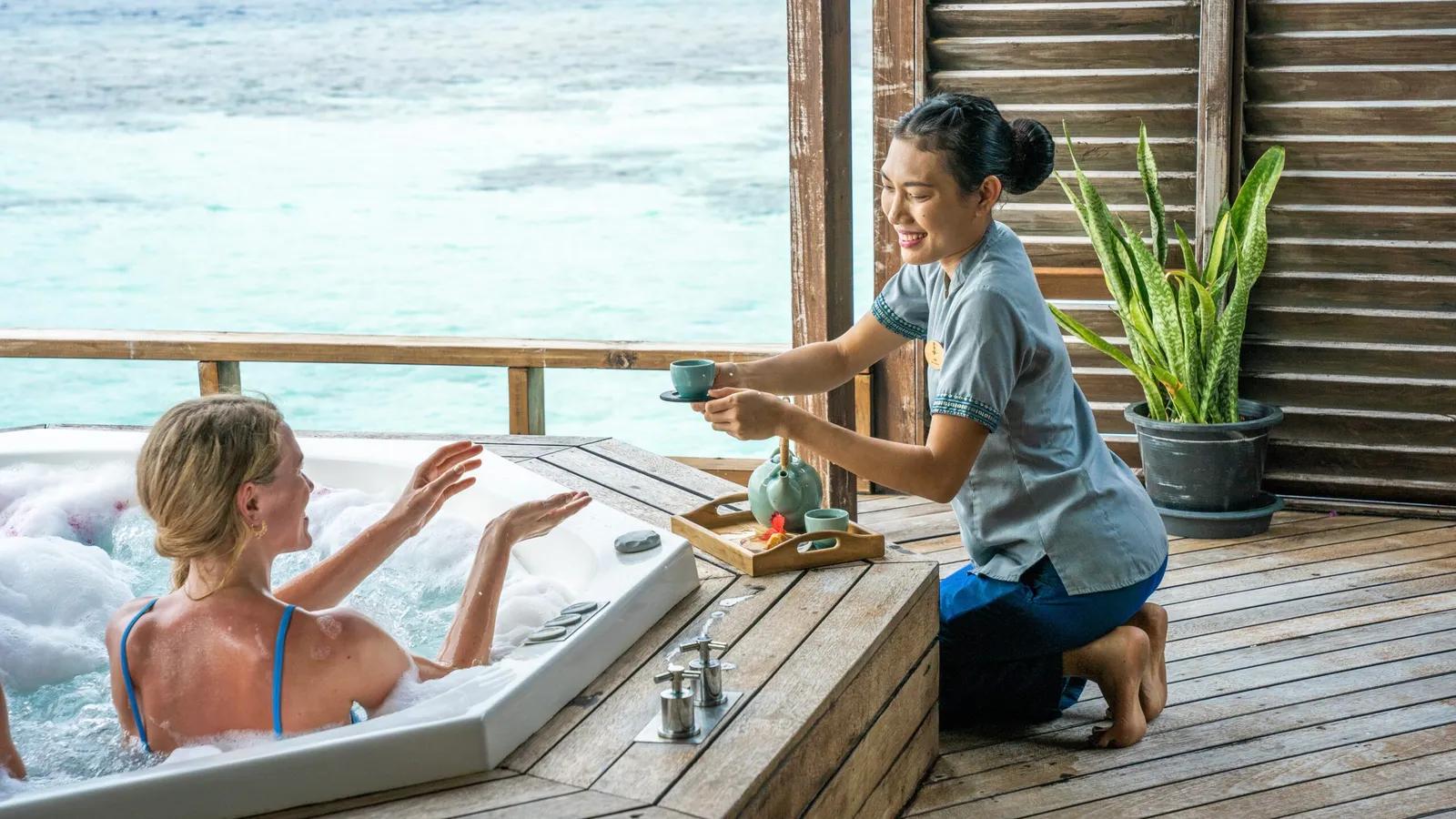 A spa treatment room opening onto the Indian Ocean lagoon at a Maldives wellness resort