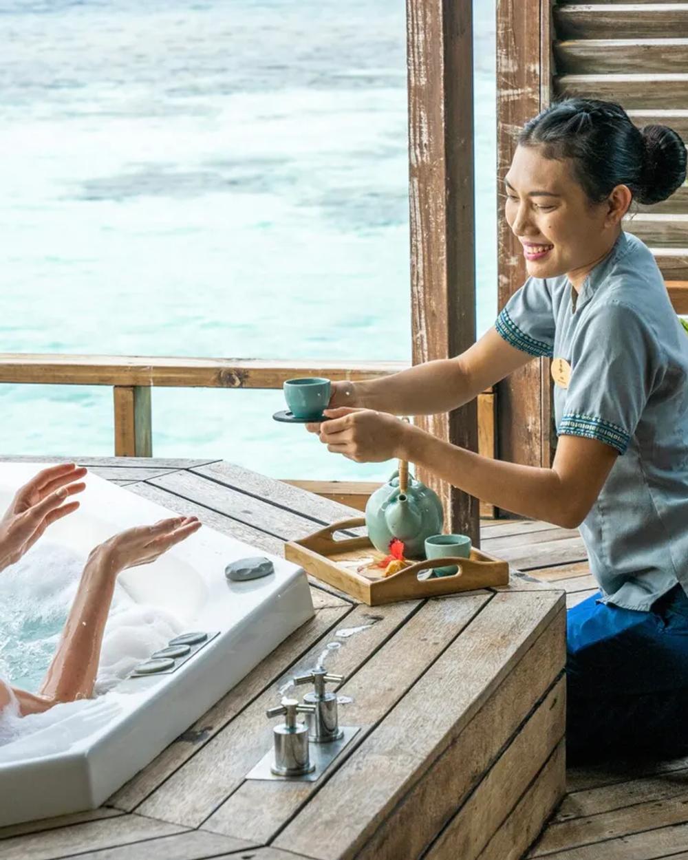 A spa treatment room opening onto the Indian Ocean lagoon at a Maldives wellness resort