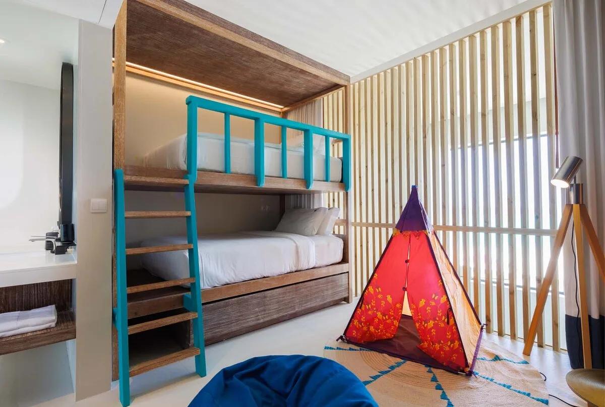 The bunk bedroom in a Silver Family Pool Suite duplex, with a play tent set up for younger guests