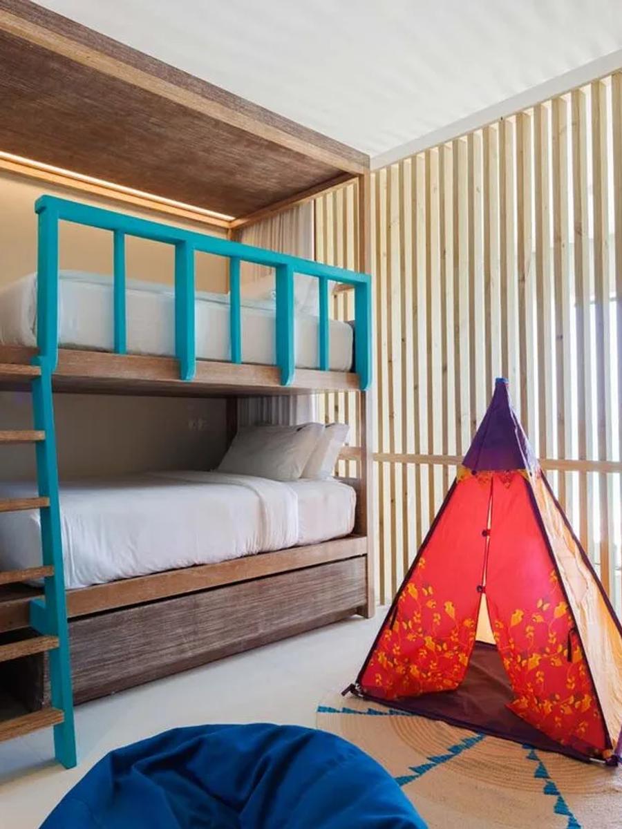 The bunk bedroom in a Silver Family Pool Suite duplex, with a play tent set up for younger guests