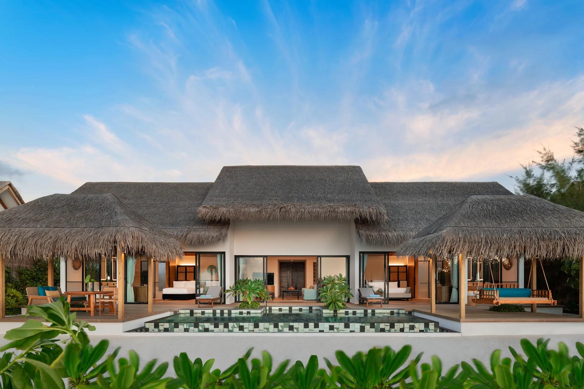 The exterior of a Two Bedroom Beach Pool Villa, set among palms on the beach