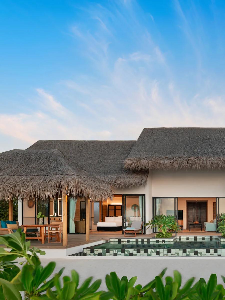 The exterior of a Two Bedroom Beach Pool Villa, set among palms on the beach
